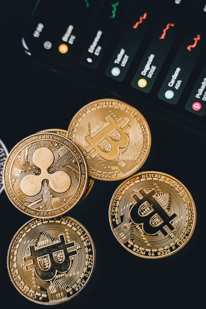 Services A detailed view of Bitcoin and Ripple coins with market data on a screen, symbolizing digital currency trends.